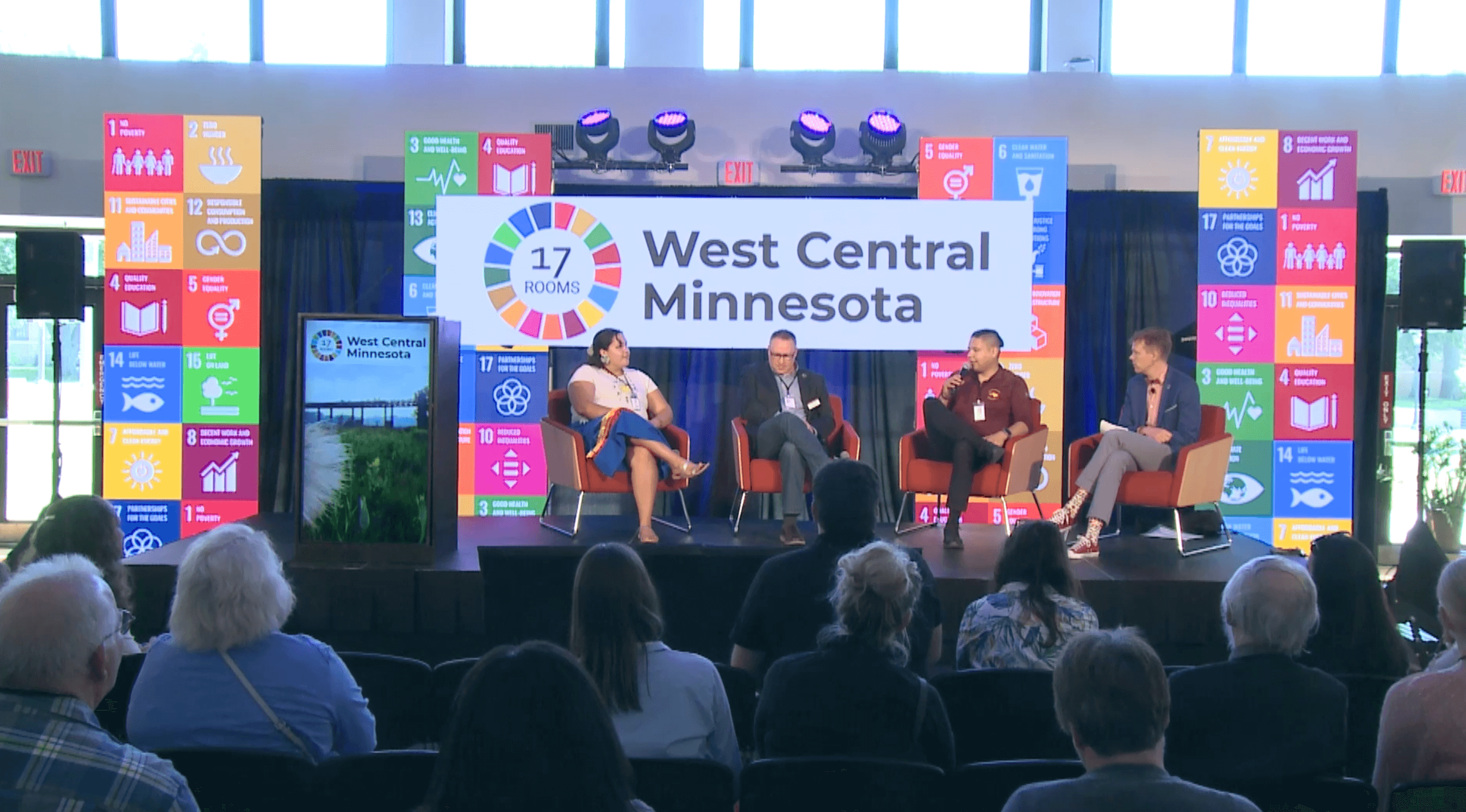 Four people sitting on stage